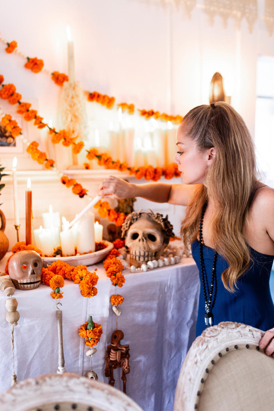 Marcela Valladolid lights a candle on her ofrenda, or altar. (Photo: Cecilia Martin Del Campo)