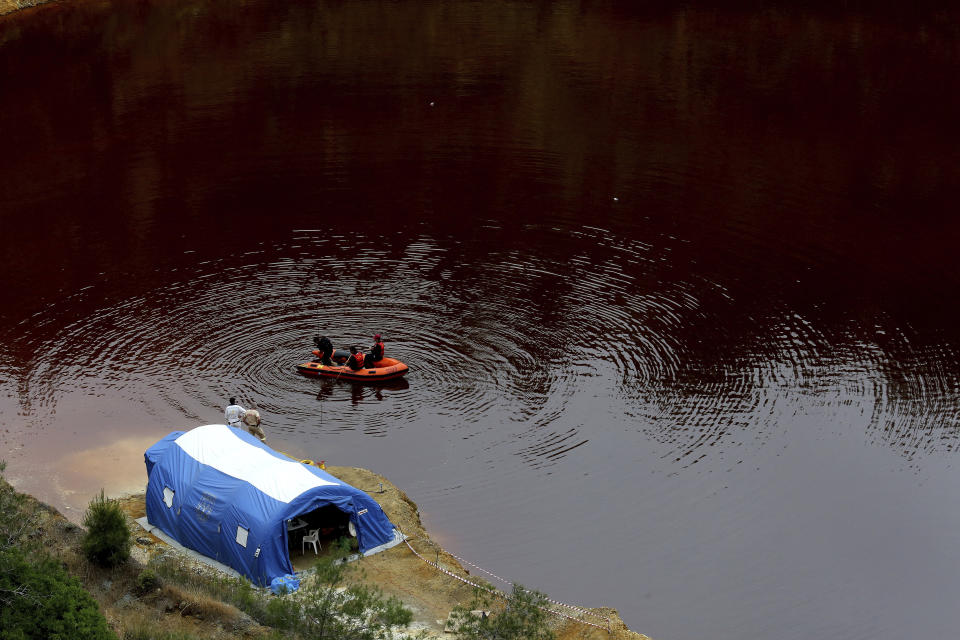 Members of the Cyprus Special Disaster Response Unit search for suitcases in a man-made lake, near the village of Mitsero outside of the capital Nicosia, Cyprus, Wednesday, May 1, 2019. Cyprus police spokesman Andreas Angelides says British experts called in to assist in the east Mediterranean island nation's serial killer case have been brought up to speed on the ongoing probe. (AP Photo/Petros Karadjias)