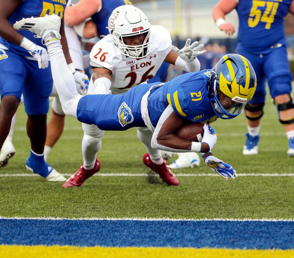 Delaware running back Marcus Yarns (21) scores in front of Elon defensive back Jesse Powell II in the second quarter at Delaware Stadium, Saturday, Nov. 4, 2023.