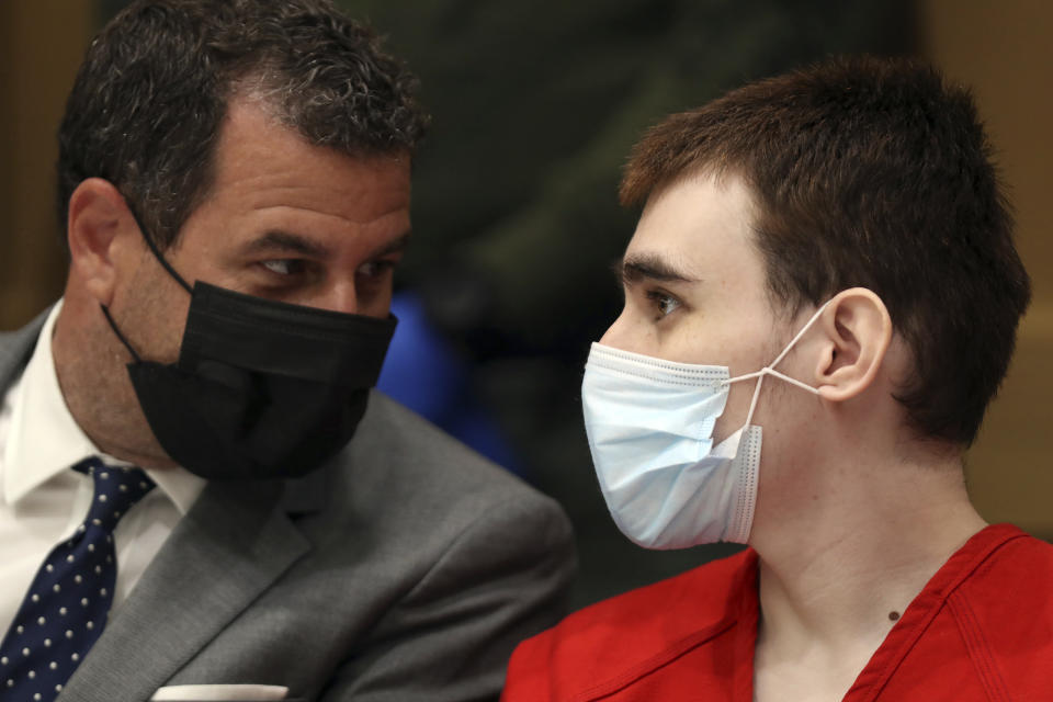 Parkland school shooter Nikolas Cruz speaks to defense attorney Gabe Ermine during a pre-trial hearing at the Broward County Courthouse in Fort Lauderdale, Fla., Wednesday, July 14, 2021, on four criminal counts stemming from his alleged attack on a Broward jail guard in November 2018. Cruz is accused of punching Sgt. Ray Beltran, wrestling him to the ground and taking his stun gun. (Amy Beth Bennett/South Florida Sun-Sentinel via AP, Pool)