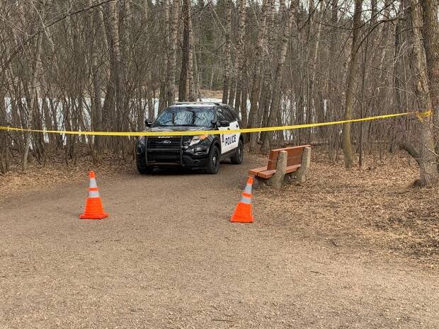  Police blocked off the trail next to the river at the Buena Vista dog park as emergency responders attempted to rescue a man who had fallen through the ice of the river. (Scott Neufeld/CBC - image credit)