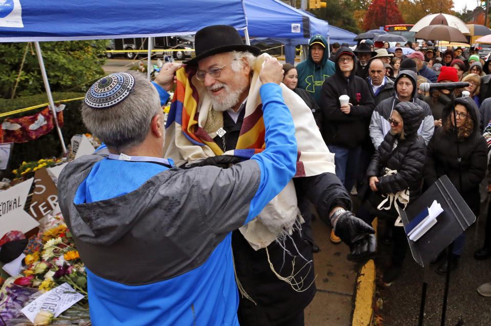 Former Rabbi at Tree of Life Synagogue, Rabbi Chuck Diamond, second from left, prepares to lead a Shabbat morning service outside the Tree of Life Synagogue Saturday, Nov. 3, 2018 in Pittsburgh. About 100 people gathered in a cold drizzle for what was called a "healing service" outside the synagogue that was the scene of a mass shooting a week ago. (AP Photo/Gene J. Puskar)