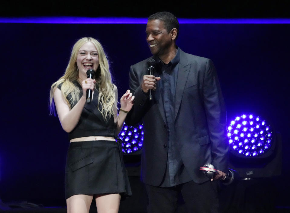 Dakota Fanning, left, and Denzel Washington, cast members in the upcoming film "The Equalizer 3," laugh onstage during the Sony Pictures presentation at CinemaCon 2023, the official convention of the National Association of Theatre Owners (NATO) at Caesars Palace, Monday, April 24, 2023, in Las Vegas. (AP Photo/Chris Pizzello)