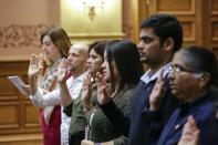 Candidates for US citizenship take the oath of allegiance during a naturalization ceremony for new US citizens at the City Hall of Jersey City in New Jersey on February 22, 2017