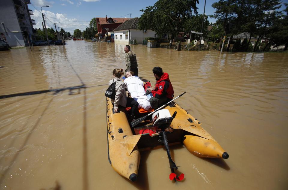 Serbian army soldiers evacuate people on a boat in the flooded town of Obrenovac