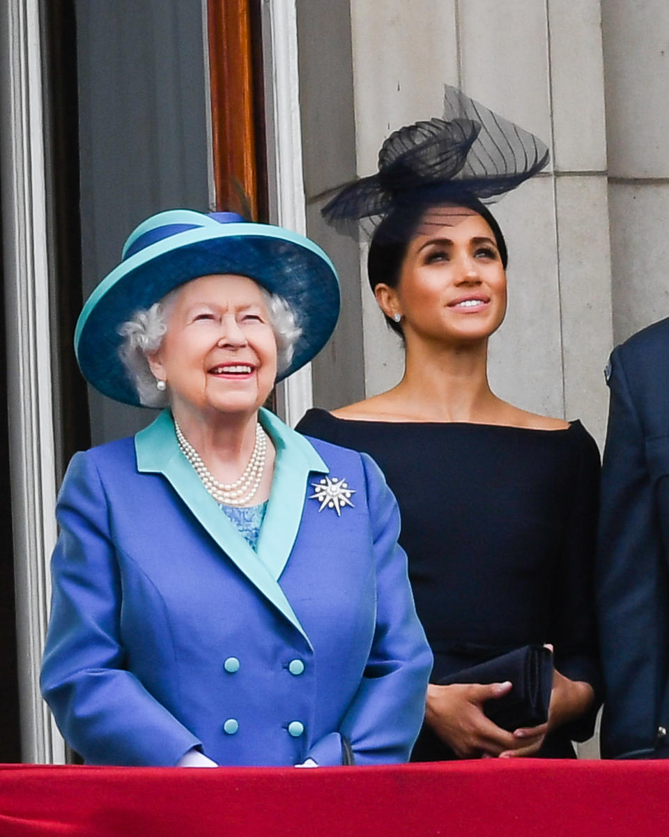 LONDON,  UNITED KINGDOM - JULY 1O:  Queen Elizabeth ll and Meghan, Duchess of Sussex stand on the balcony of Buckingham Palace to view a flypast to mark the centenary of the Royal Air Force (RAF)  on July 10, 2018 in London, England. (Photo by Anwar Hussein/WireImage)