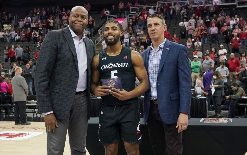 Nov 23, 2021; Kansas City, Missouri, USA; National Basketball Association Executive director Craig Robinson presents Cincinnati Bearcats guard David DeJulius (5) an all tournament team award after their loss to the Arkansas Razorbacks at T-Mobile Center. Mandatory Credit: Denny Medley-USA TODAY Sports