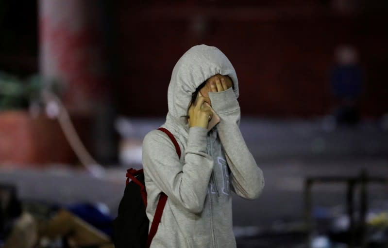 An anti-government demonstrator cries after coming out of the Hong Kong Polytechnic University (PolyU) to surrender, in Hong Kong