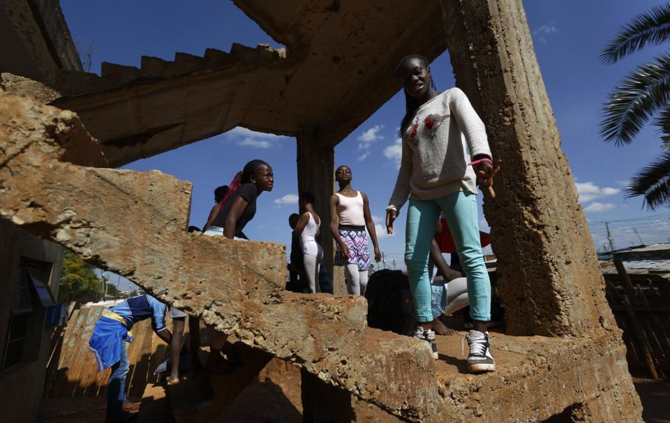 In this photo taken Friday, Dec. 9, 2016, young ballerinas gather on steps leading from the room where Kenyan ballet dancer Joel Kioko, 16, gave a class, at a school in the Kibera slum of Nairobi, Kenya. In a country not usually associated with classical ballet, Kenya's most promising young ballet dancer Joel Kioko has come home for Christmas from his training in the United States, to dance a solo in The Nutcracker and teach holiday classes to aspiring dancers in Kibera, the Kenyan capital's largest slum. (AP Photo/Ben Curtis)