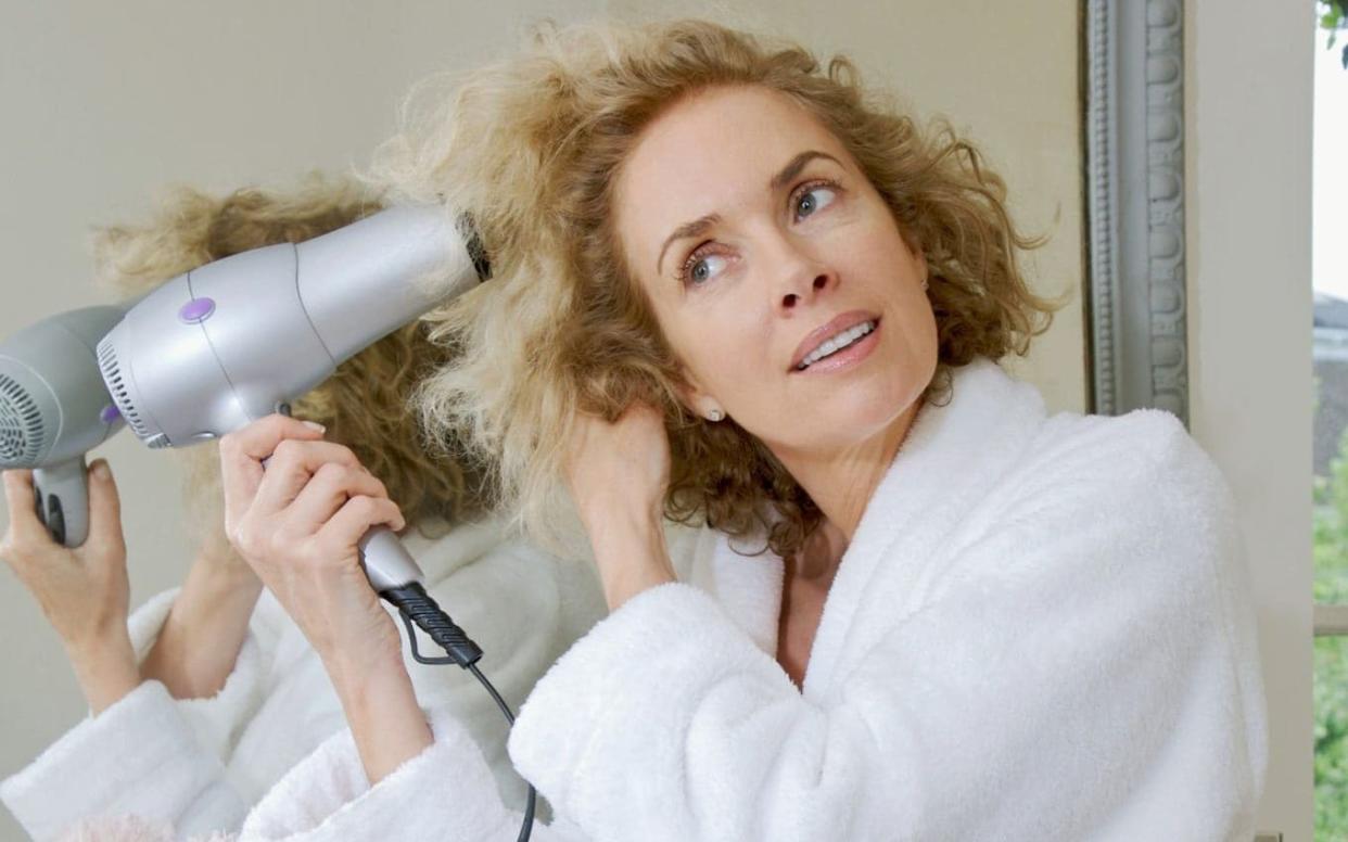 Woman blow-drying hair - Image Source 