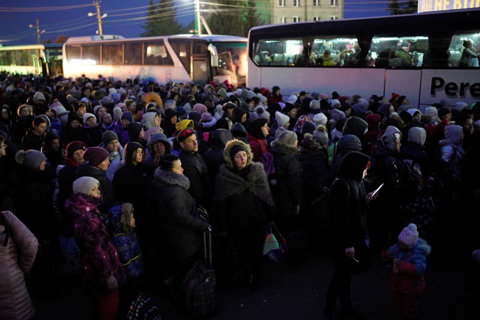 Refugees fleeing the war in Ukraine, form a line as they approach the border with Poland in Shehyni, Ukraine, Sunday, March 6, 2022. The number of Ukrainians forced from their country increased to 1.5 million and the Kremlin's rhetoric grew, with Russian President Vladimir Putin warning that Ukrainian statehood is in jeopardy. (AP Photo/Daniel Cole)