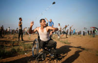 A disabled Palestinian uses a sling to hurl stones at Israeli troops during a protest demanding the right to return to their homeland at the Israel-Gaza border, in Gaza August 17, 2018. REUTERS/Mohammed Salem