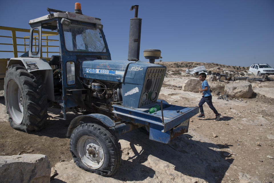 A tractor with a shattered windshield and flat tires following a settlers' attack from nearby settlement outposts on the Palestinian Bedouin community, in the West Bank village of al-Mufagara, near Hebron, Thursday Sept. 30, 2021. An Israeli settler attack last week damaged much of the village’s fragile infrastructure. (AP Photo/Nasser Nasser)