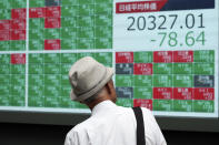 A man looks at an electronic stock board showing Japan's Nikkei 225 index at a securities firm in Tokyo Friday, Aug. 16, 2019. Asian shares were mixed Friday as turbulence continued on global markets amid ongoing worries about U.S.-China trade conflict. (AP Photo/Eugene Hoshiko)