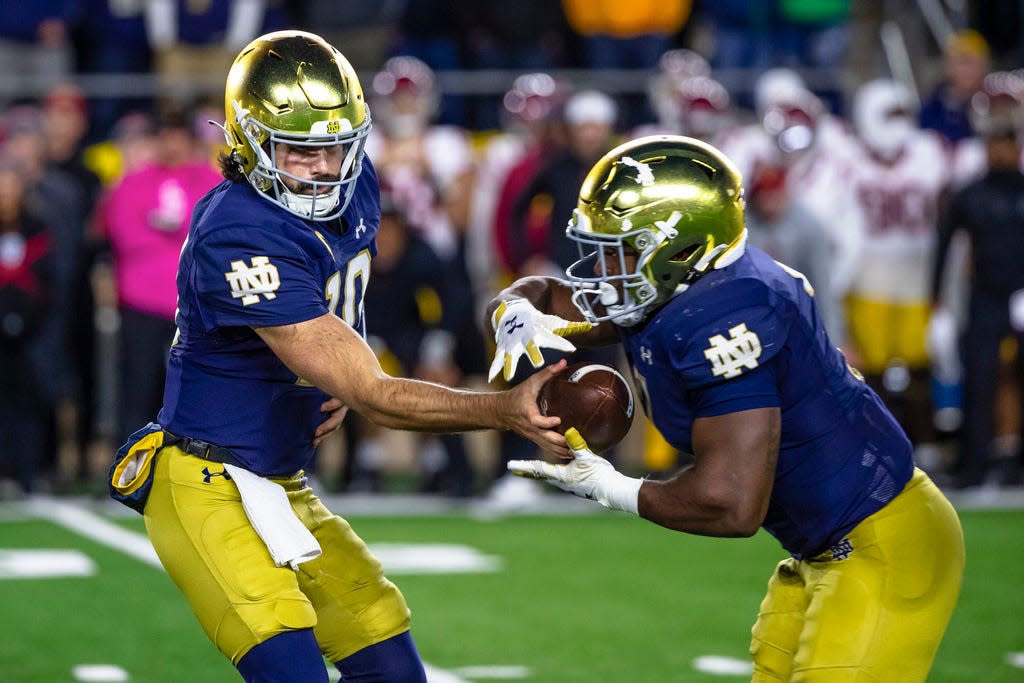 Notre Dame quarterback Sam Hartman (10) hands off to running back Audric Estime (7) during the second half of an NCAA college football game against Southern California Saturday, Oct. 14, 2023, in South Bend, Ind. (AP Photo/Michael Caterina)