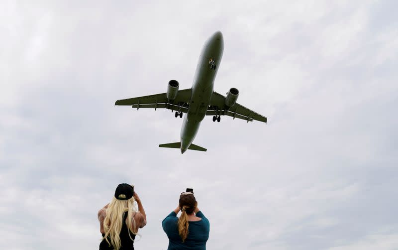 Flight attendants photograph a plane landing in Washington during the coronavirus crisis