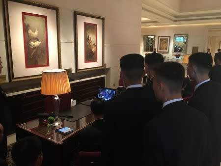 North Korean security gather around a small screen at the St Regis hotel in Singapore to watch their leader Kim Jong Un meet U.S. President Donald Trump, June 12, 2018. Picture taken June 12, 2018. REUTERS/John Geddie