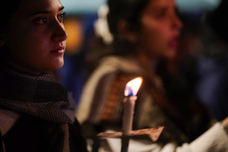 Relatives and friends of hostages held in the Gaza Strip by the Hamas militant group hold candles and call for their release during the Jewish holiday of Hanukkah, in Jerusalem, Tuesday, Dec. 12, 2023. (AP Photo/Leo Correa)