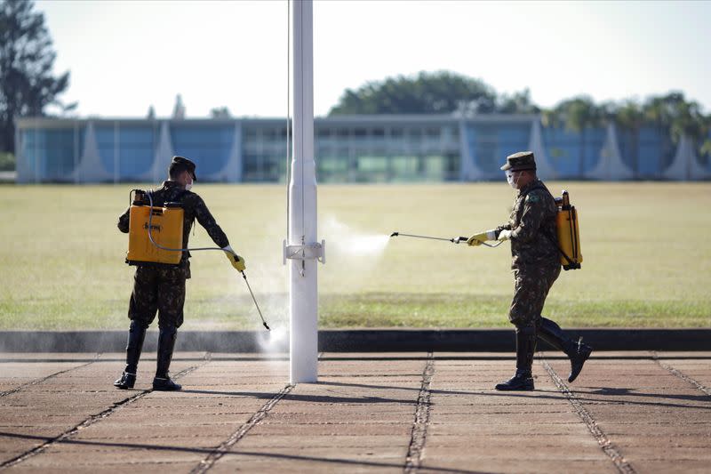 Members of the armed forces disinfect the entrance of the Alvorada Palace