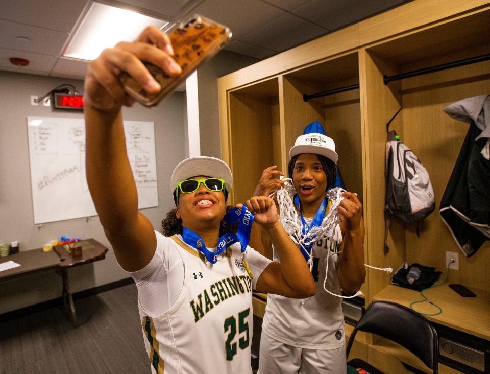 Washington's Lauren Gillon (25) and Shamarah Allen (14) take a selfie after winning the Washington vs. Silver Creek girls state championship basketball game Saturday, Feb. 26, 2022 at Gainbridge Fieldhouse in Indianapolis. 