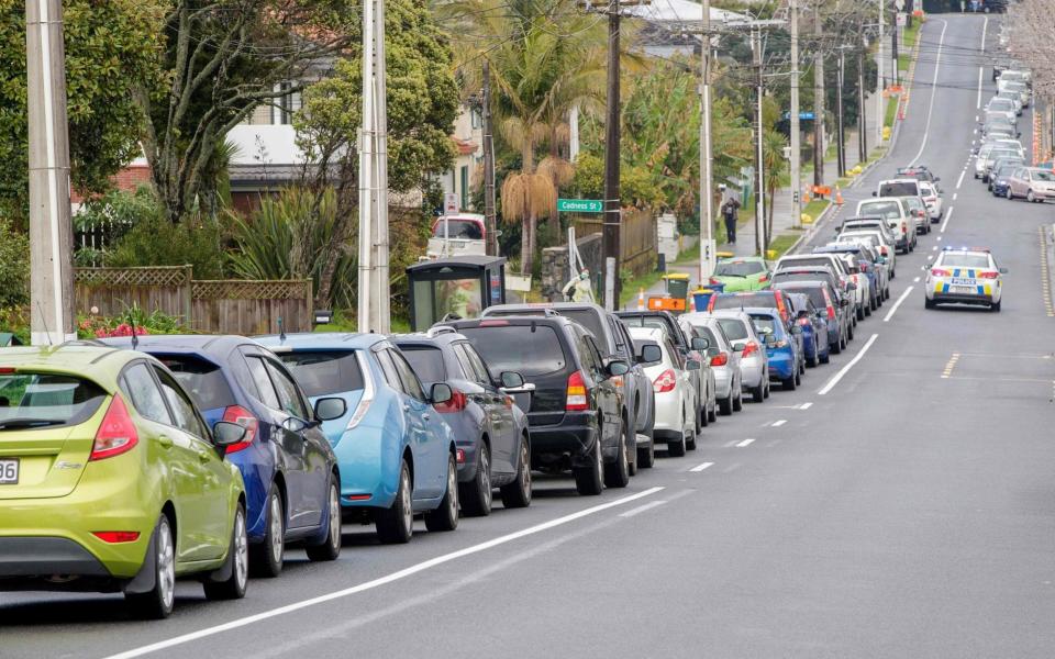 Motorists queue at a coronavirus testing centre in the suburb of Northcote in Auckland - AFP