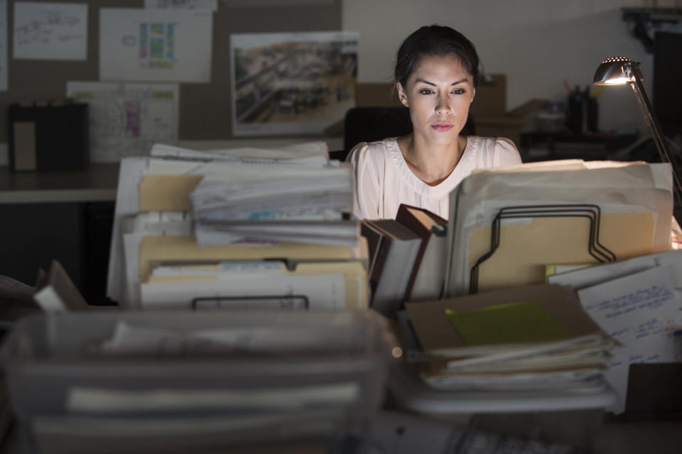Mixed race businesswoman working late in office