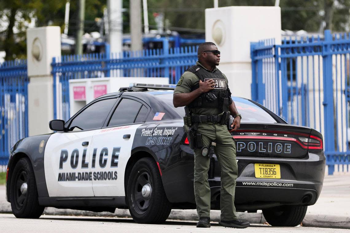 A Miami-Dade Schools officer stands by his vehicle outside Miami Northwestern Senior High in Miami, Florida, Friday, January 12, 2024. Miami-Dade Public Schools increased its police presence at the school the day after a student was shot on campus following a boys basketball game.