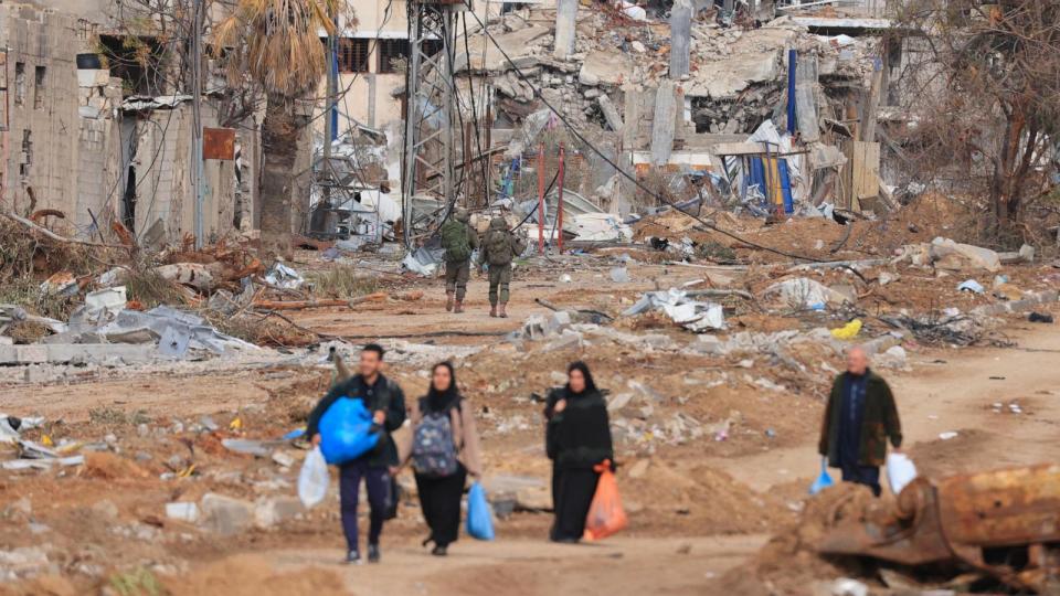 PHOTO: Israeli soldiers walk past Palestinians fleeing the north along the Salaheddine road in the Zeitoun district on the southern outskirts of Gaza City, Nov. 28, 2023. (Mahmud Hams/AFP via Getty Images)