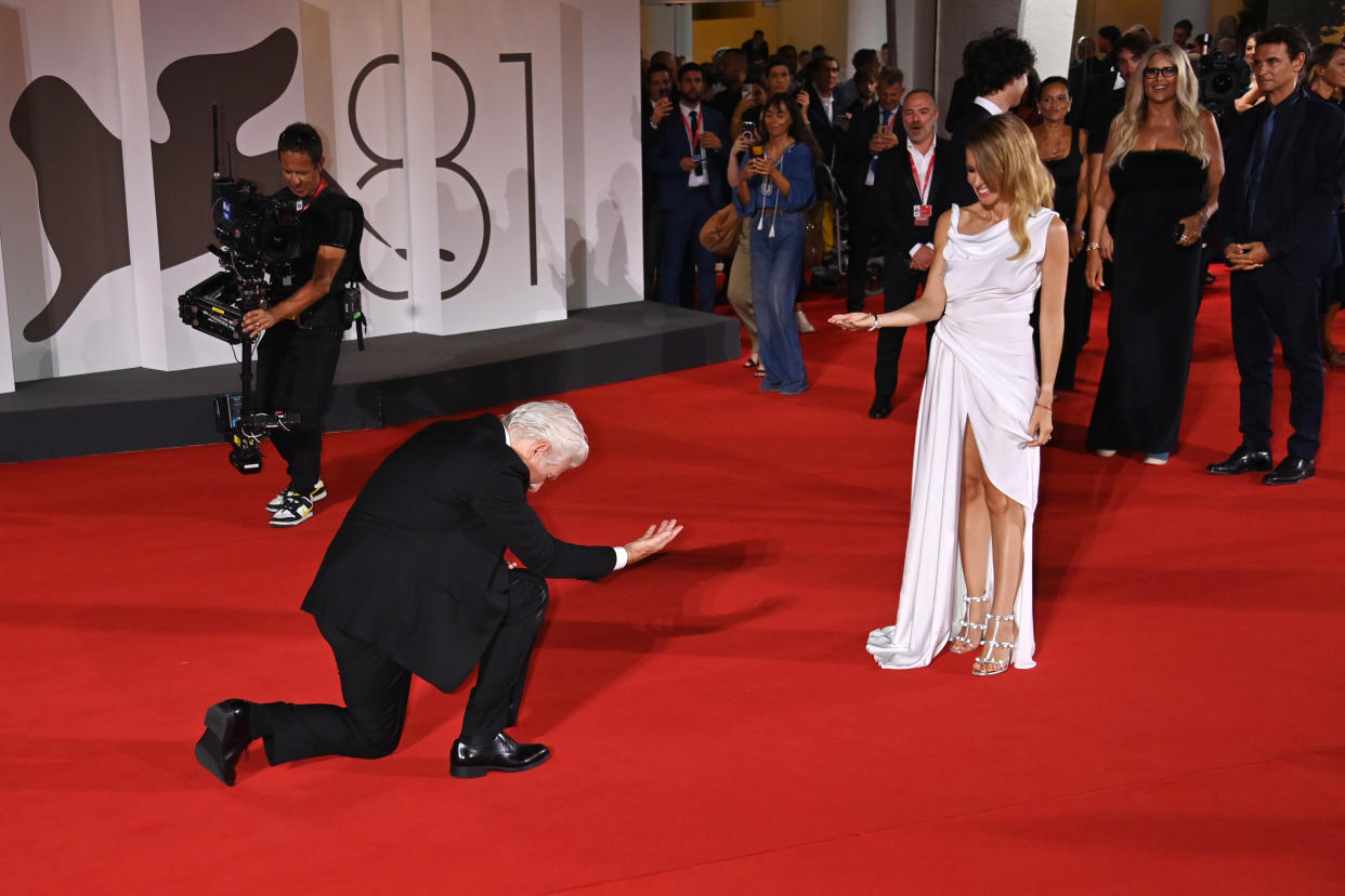 Gere drops to one knee in front of Silva on the red carpet.