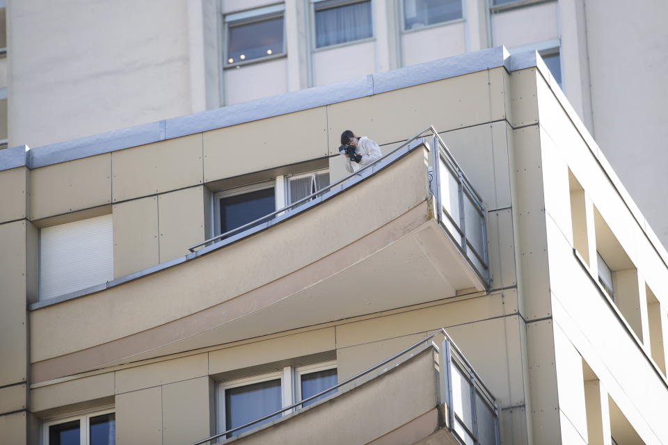 A forensic officer from the Vaud cantonal police investigates at the scene of the tragedy where four people died and one was seriously injured after falling from their flat in Montreux, Switzerland, 24 March 2022. 