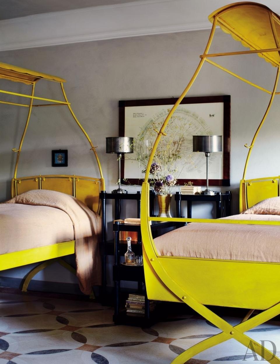 Architect Benedikt Bolza designed a guest room's yellow twin steel beds in his <a rel="nofollow noopener" href="https://www.architecturaldigest.com/story/architect-benedikt-bolza-umbria-italy-farmhouse-article?mbid=synd_yahoo_rss" target="_blank" data-ylk="slk:Umbria, Italy, home;elm:context_link;itc:0;sec:content-canvas" class="link ">Umbria, Italy, home</a>; his wife, Nencia, hand-painted the floor.