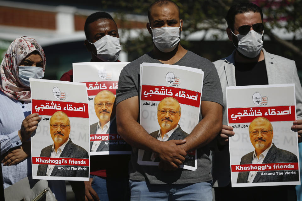 People hold posters of slain Saudi journalist Jamal Khashoggi, near the Saudi Arabia consulate in Istanbul, marking the two-year anniversary of his death, Friday, Oct. 2, 2020. The gathering was held outside the consulate building, starting at 1:14 p.m. (1014 GMT) marking the time Khashoggi walked into the building where he met his demise. (AP Photo/Emrah Gurel)