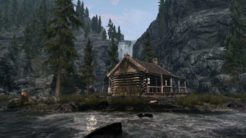 Best Skyrim mods — a woodland cabin beside a waterfall-fed stream.