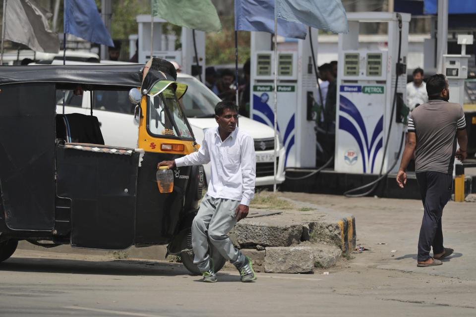 A physically disabled Kashmiri man waits for transport after buying fuel from a fuel station in Srinagar, India, Sunday, Aug. 4, 2019. People in Srinagar and other towns in Indian kashmir thronged grocery stores and medical shops to stock up on essentials. Tensions have soared along the volatile, highly militarized frontier between India and Pakistan in the disputed Himalayan region of Kashmir as India deployed more troops and ordered thousands of visitors out of the region. (AP Photo/Mukhtar Khan)