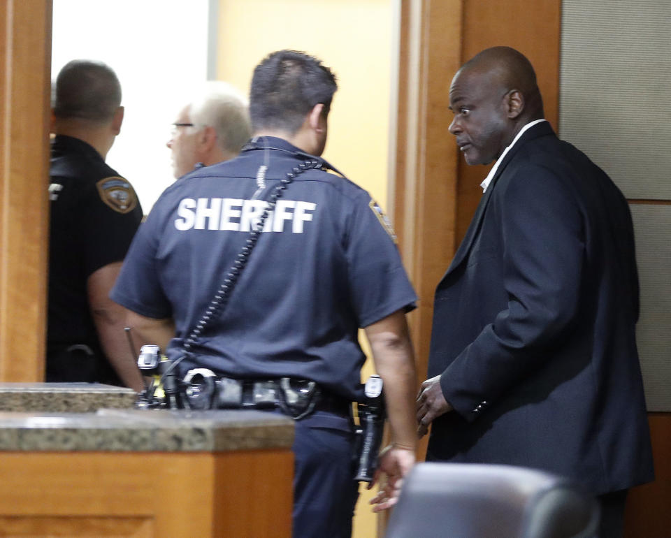 Former Houston police officers Gerald Goines walks toward deputies who were prepared to place him into custody along with Steven Bryant, after they turned themselves in at the Civil Courthouse, Friday, Aug. 23, 2019, in Houston. Goines, a former Houston police officer has been charged with murder in connection with the deadly January drug raid of a home that killed a couple who lived there and injured five officers, prosecutors announced Friday. (Karen Warren/Houston Chronicle via AP)