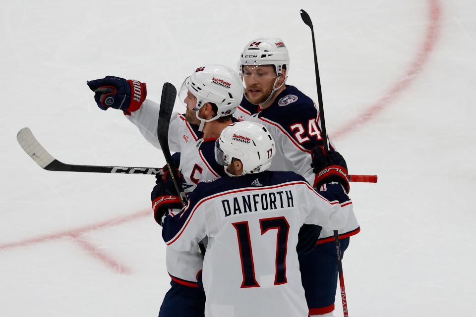 Columbus Blue Jackets center Boone Jenner, center, is congratulated by teammates Mathieu Olivier and Justin Danforth after scoring a goal against the Boston Bruins during the second period of an NHL hockey game, Sunday, Dec. 3, 2023, in Boston. (AP Photo/Mary Schwalm)