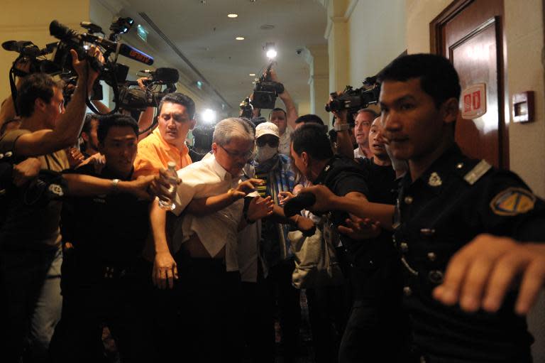 A Chinese relative of passengers from the missing Malaysia Airlines flight is stopped and escorted away by Malaysian police from entering the media centre before the start of a press conference at a hotel near Kuala Lumpur airport on March 19, 2014