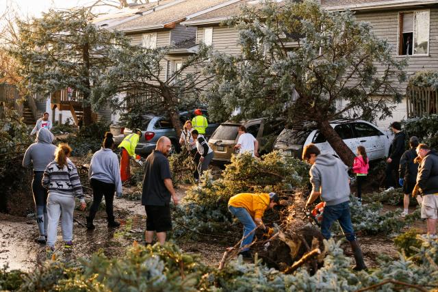 Cleanup begins after a tornado touched down near the intersection of 23rd Avenue and Ninth Street in Coralville, Iowa, Friday, March 31, 2023. City crews, residents and neighbors worked to clear debris off the roadway and vehicles. (Jim Slosiarek/The Gazette via AP)