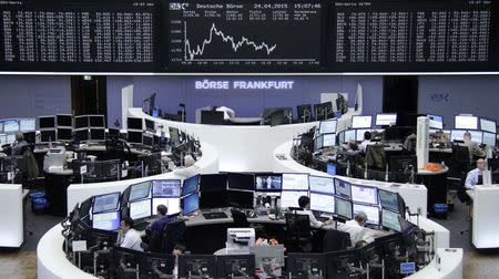 Traders are pictured at their desks in front of the DAX board at the Frankfurt stock exchange April 24, 2015. REUTERS/Remote/Staff