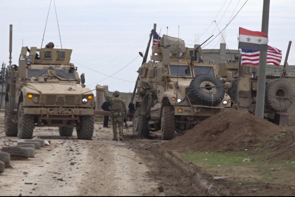 In this frame grab from video, an American military convoy is seen in the village of Khirbet Ammu, east of Qamishli city, Syria, Wednesday, Feb. 12, 2020. Syrian media and activists say a Syrian was killed and another wounded in a rare clash between American troops and a group of government supporters in northeast Syria. (AP Photo)