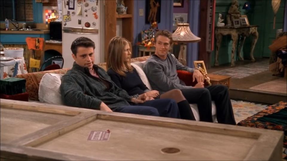 Joey and co. sitting on the couch while Chandler lays in a box in "Friends"