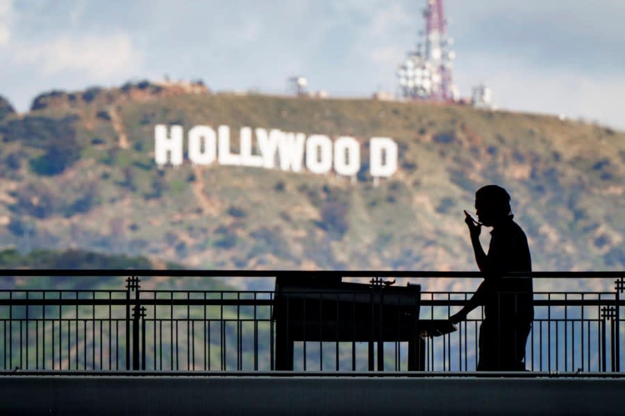 A worker wheels equipment past the famous Hollywood sign as preparations continue Wednesday, Mar. 8, 2023, for the 95th Academy Awards on Sunday at the Dolby Theatre in Los Angeles. (AP Photo/J. David Ake)