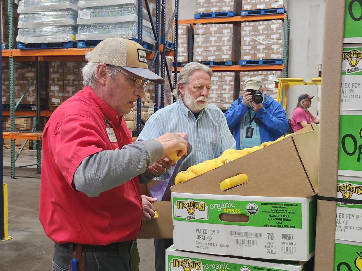 United Family representatives prepare apples to be donated to those in need. More than 5,000 pounds of apples were given to the High Plains Food Bank to distribute Wednesday morning.