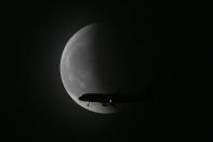 <p>SHENYANG, CHINA - MAY 26: A plane flies past the super moon during the total lunar eclipse on May 26, 2021 in Shenyang, Liaoning Province of China. (Photo by VCG/VCG via Getty Images)</p> 