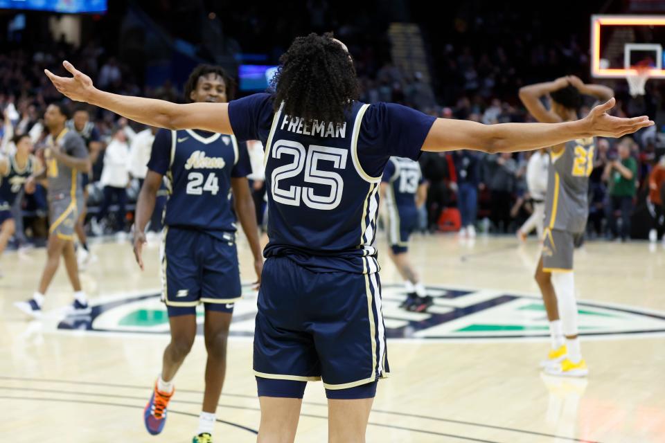 Akron's Enrique Freeman (25) and Ali Ali (24) celebrate a win against Kent State for the championship of the Mid-American Conference Tournament, Saturday, March 12, 2022, in Cleveland. (AP Photo/Ron Schwane)