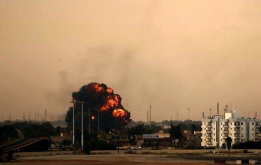 Smoke billows after a Libyan jet bomber crashed after being shot down in Benghazi. French air raids and US Tomahawk missiles pounded targets in Libya on Saturday, in an international campaign to prevent Moamer Kadhafi from crushing a month-old uprising against his rule