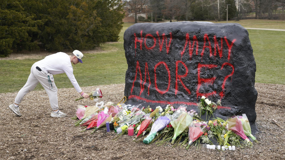 A student leaves flowers at The Rock on the grounds of Michigan State University, in East Lansing, Mich., Tuesday, Feb. 14, 2023. A gunman killed several people and wounded others at Michigan State University. Police said early Tuesday that the shooter eventually killed himself. (AP Photo/Paul Sancya)