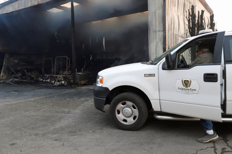 A worker assesses the damage to a building burnt by Kincade Fire at Fieldstone Farm in Santa Rosa, California