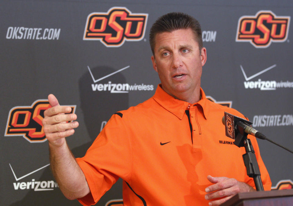FILE - Oklahoma State head coach Mike Gundy gestures as he answers a question during a news conference in Stillwater, Okla., Oct. 24, 2011. Oklahoma and Oklahoma State will meet on Saturday for the final time before Oklahoma leaves the Big 12 for the Southeastern Conference. (AP Photo/Sue Ogrocki, File)