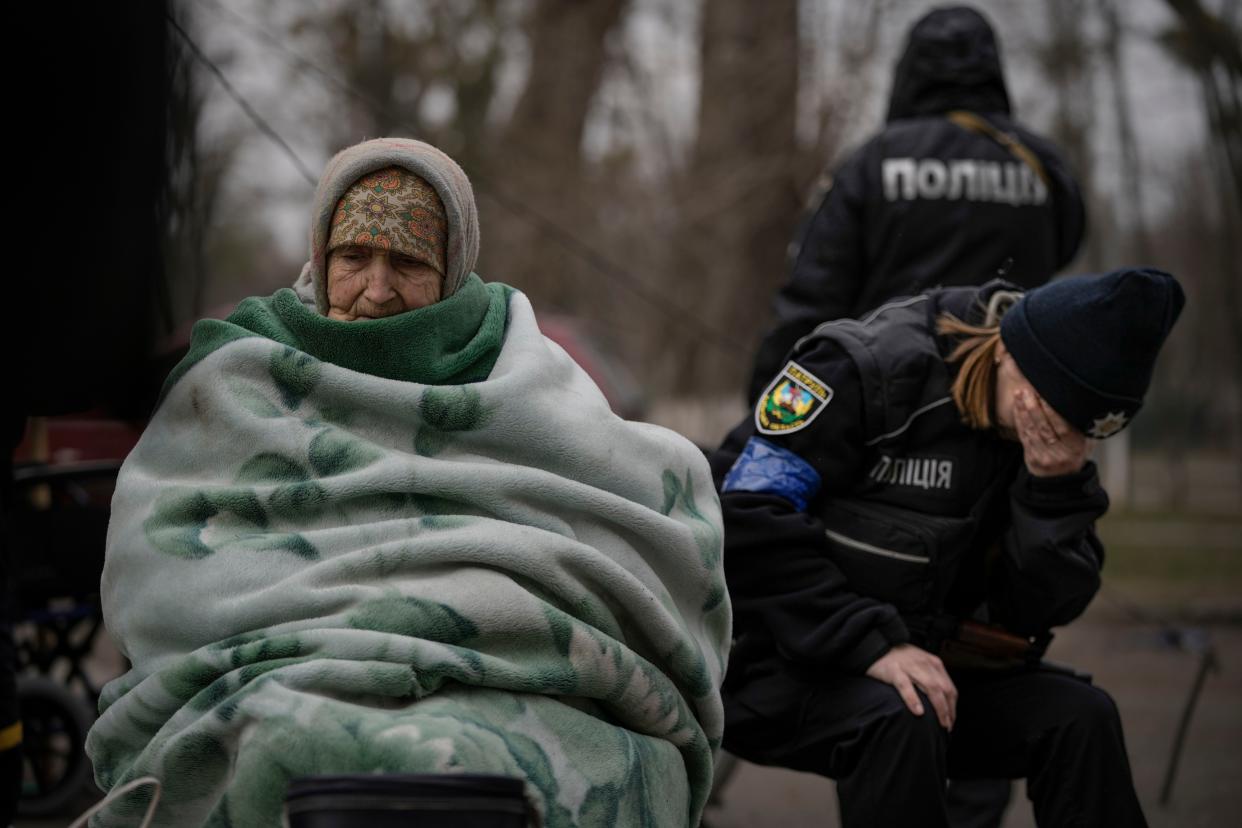 A Ukrainian police officer is overwhelmed by emotion after comforting people evacuated from Irpin, Ukraine, on the outskirts of Kyiv, on Saturday.